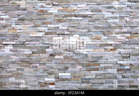 External wall covering made of brick stones of different colors. Full frame. Background and texture. Stock Photo