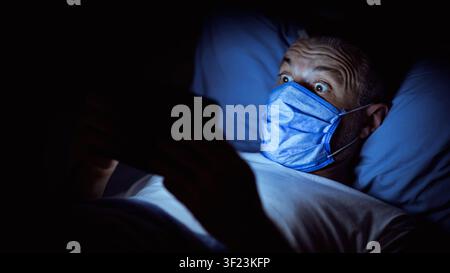 Shocked Man Reading News On Tablet Overnight At Home, Panorama Stock Photo