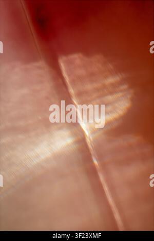 Abstract warm light refraction with soft geometric reflections in amber, peach, and cream tones. Stock Photo