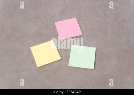 Three blank sticky notes are scattered on a background, representing planning, organization, and communication Stock Photo