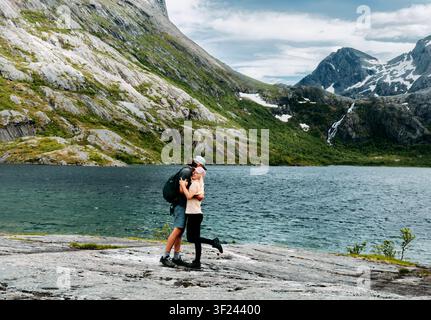 Couple hugging in love enjoying vacations in Norway travel hiking together man and woman on summer romantic holidays tour in Aselidalen, happy family Stock Photo
