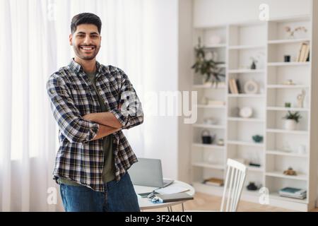 Smiling Young Man Standing Confidently In Modern Office, Business Concept Stock Photo