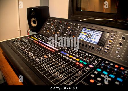 This is a modern professional sound mixing console used in recording studios for music production and sound engineering. It features digital controls, Stock Photo