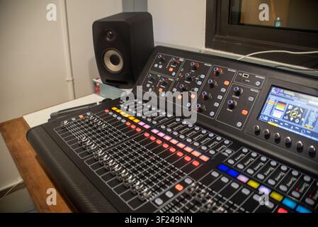 This professional audio mixing console is equipped with multiple controls, touch screen interface, and monitor speakers, perfect for music production, Stock Photo