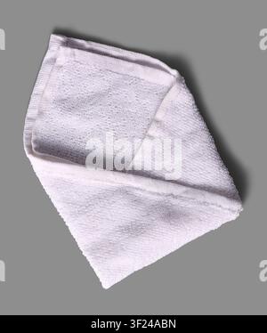 folded white towel isolated gray background, soft terry cloth fabric and textured cotton material, top view Stock Photo