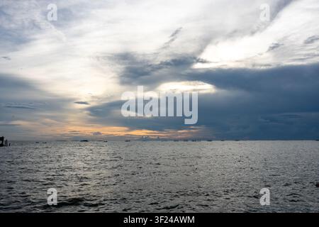 This expansive image captures a tranquil ocean scene under a vast, partly cloudy sky with dramatic weather patterns, showcasing the natural beauty of Stock Photo