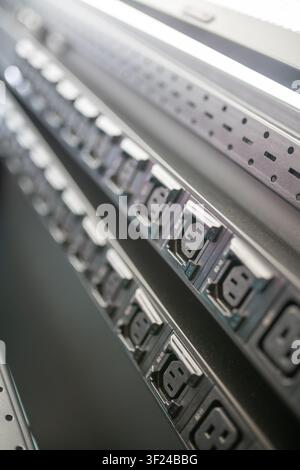 Close-up shot of a power strip featuring multiple electrical outlets for connecting electronic devices, with a sleek modern design perfect for home or Stock Photo