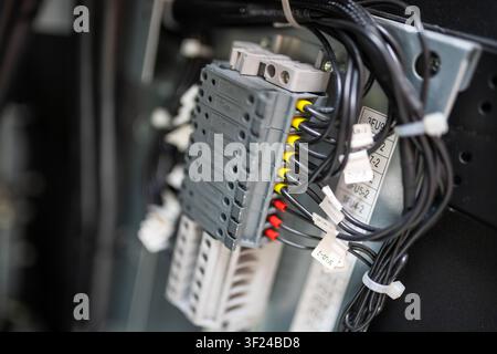 Close-up of an electrical panel featuring circuit breakers and wiring harnesses, showcasing components involved in electrical distribution and control Stock Photo