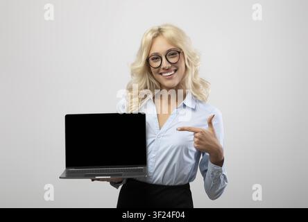 Smiling Caucasian Woman Pointing At Blank Laptop Screen, Business Concept Stock Photo