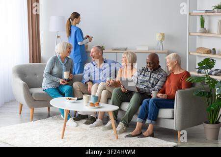Happy Senior Diverse Group Socializing And Enjoying Snacks At Home, Healthcare Concept Stock Photo