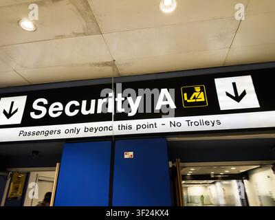 Large illuminated Security A sign at Manchester Airport terminal directing passengers toward the checkpoint and screening area. Stock Photo