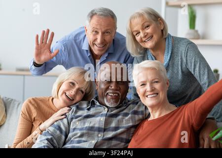 Happy Senior Multiethnic Group Of Friends Smiling Together At Home, Joyful Moment Stock Photo