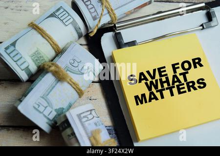 Concept of save for what matters write on sticky notes isolated on Wooden Table. Stock Photo