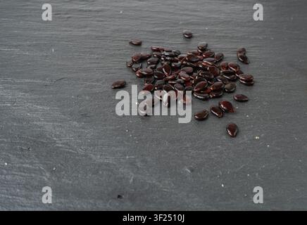Watermelon Seeds on Black, Water Melon Black Seed Pile, Small Black Kernels, Raw Scattered Watermelon Seeds on Dark Stone Plate Background Stock Photo