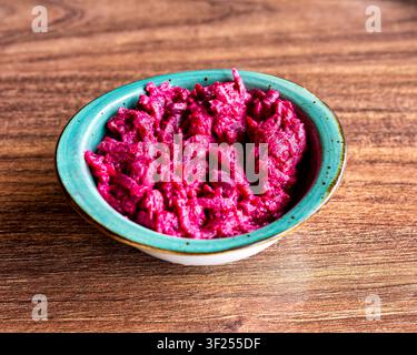 Traditional Turkish Pancar Salatası with grated beetroot and creamy dressing in turquoise bowl. Stock Photo