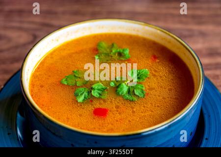 Traditional Azeri style chicken and vegetable soup with rice, carrots and fresh parsley garnish served in Baku, Azerbaijan. Stock Photo
