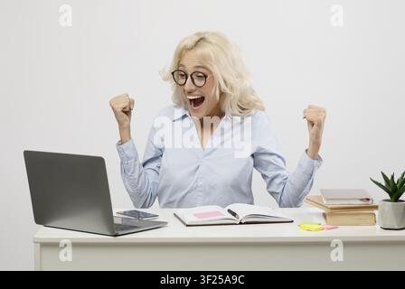 Happy Young Woman Celebrating Success At Home Office, Business Concept Stock Photo