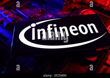 Infineon Technologies Company Logo Displayed On Smartphone Screen With Computer Showing Stock Market Performance Chart Stock Photo