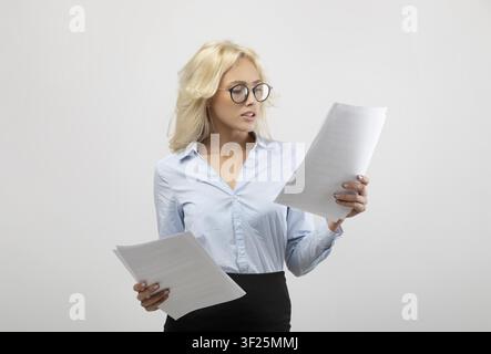 Young Caucasian Woman Reading Documents In Office, Focused On Work, Business Concept Stock Photo