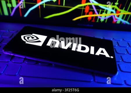 NVIDIA Logo Displayed on Smartphone in Front of Financial Performance Chart Representing Leading Artificial Intelligence and Graphics Technology Compa Stock Photo