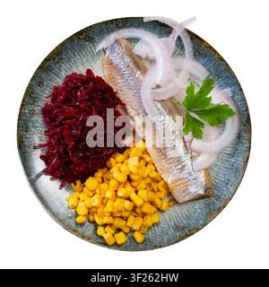 Herring served on plate with grated beetroot and corn Stock Photo