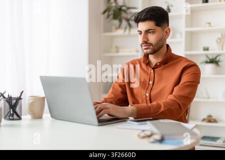Focused Male Working On Laptop In Modern Office, Business Concept Stock Photo
