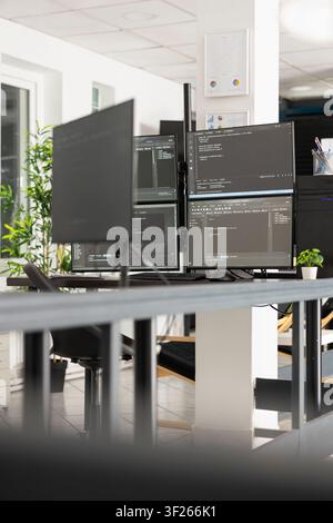 Multimonitor setup showing html scripts in vacant, bright and modern office environment, reflecting software development and advanced technology. Unoccupied workspace having computer screens with code Stock Photo