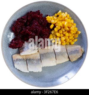 Herring served on plate with grated beetroot and corn Stock Photo
