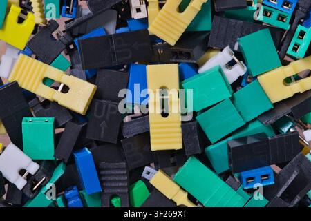 Circuit board jumper caps plastic computer components scattered loosely. Stock Photo