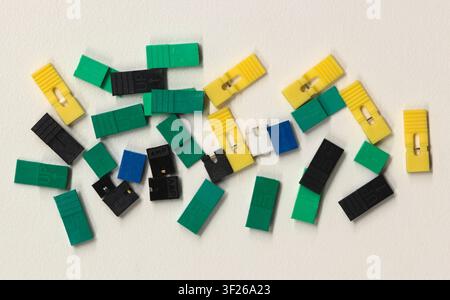 Circuit board jumper caps plastic computer components scattered loosely on white background. Stock Photo