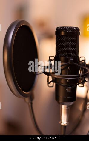 Professional microphone is ready in a home studio for podcast recording, digital streaming and online media production with broadcast equipment. Stock Photo