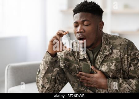 African American Man Using Inhaler For Asthma In Healthcare Setting, Concerned Expression Stock Photo