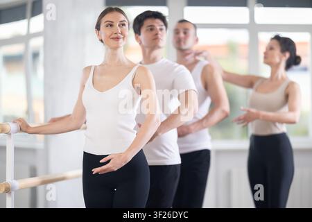 Woman improving ballet postures at group class with female teacher Stock Photo