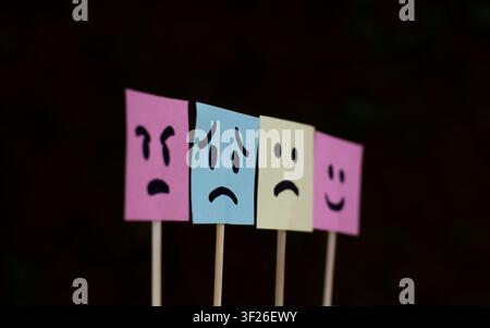 Four Colorful Mood Face Notes on Dark Background Stock Photo