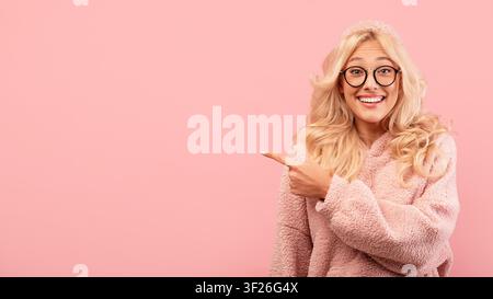 Smiling Young Caucasian Woman Pointing To Side, Cheerful Expression, Copy Space Stock Photo