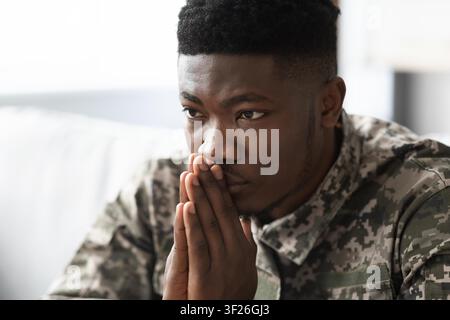 Thoughtful Black Male Soldier Deep In Thought, Home Office Setting, Mental Wellness Concept Stock Photo