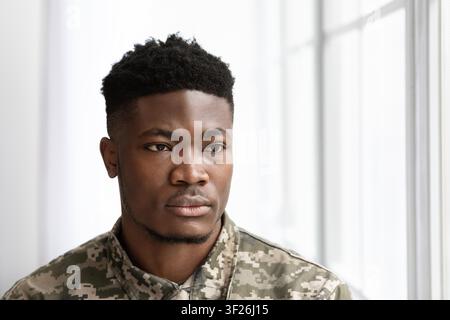 Serious Young Black Man Looking Thoughtfully In Office Environment, Business Concept Stock Photo