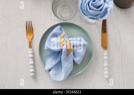 Elegant table setting with light blue linen napkin and Gold leaf napkin ring on a mint green plate Stock Photo