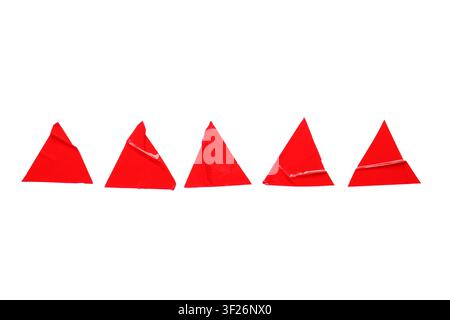 Five red triangular adhesive stickers with peeled corners arranged in a row on a white background, the stickers are isolated on a clean white backgrou Stock Photo