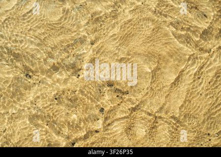 Close-up view of a textured, cracked, and dry desert or arid land surface with subtle undulating patterns. Stock Photo