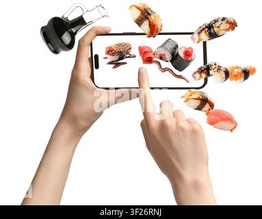 Hands holding smartphone with floating sushi and soy sauce bottle Stock Photo