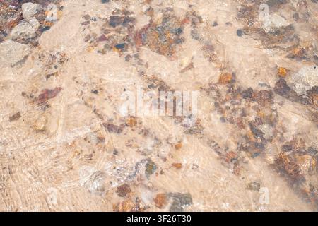 Close-up view of a textured granite surface displaying natural variations in color and mineral composition. Stock Photo