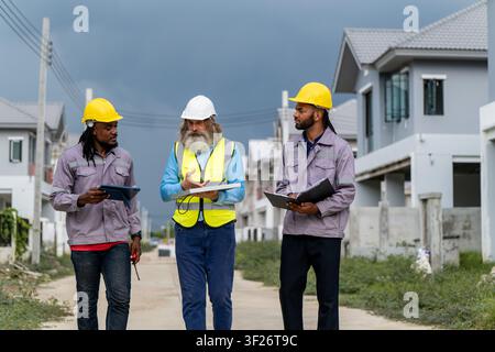 Engineers discussed preparation for installing small solar panels in residential village construction areas for sustainable energy projects and improv Stock Photo