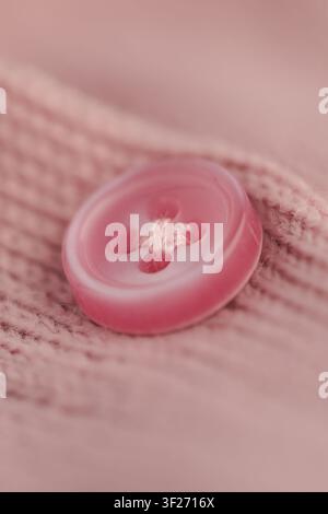 Bright pink button on soft fabric in close up view Stock Photo