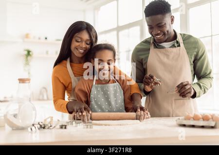 Happy African American Family Baking Together In Kitchen, Mother, Father, Daughter Smiling Stock Photo