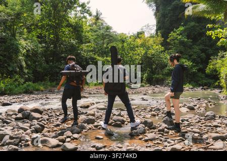 group of young asian trekking and hiking on rocky river stream Stock Photo