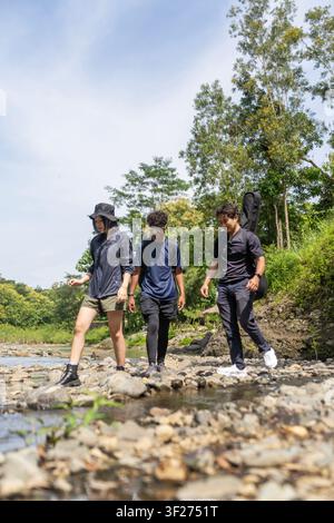 group of young asian trekking and hiking on rocky river stream Stock Photo