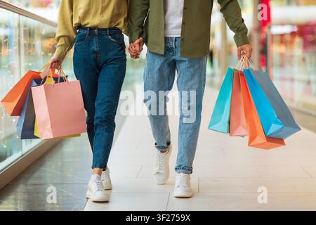 Couple Holding Shopping Bags Walking Together In Mall, Shopping Lifestyle Concept Stock Photo