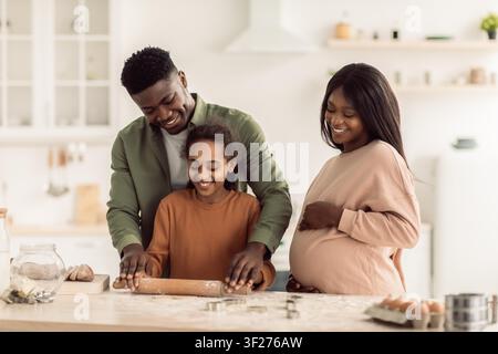 Happy African American Family Baking Together In Modern Kitchen, Expecting New Baby Stock Photo