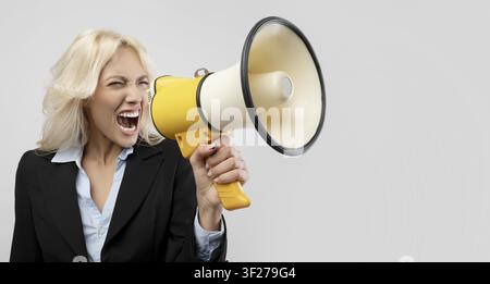 Angry Blonde Woman Holding Megaphone In Business Suit, Office Concept Stock Photo